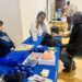 Omega Psi Phi Health Brain Aging Event photo of event participant interacting with table and having blood pressure taken