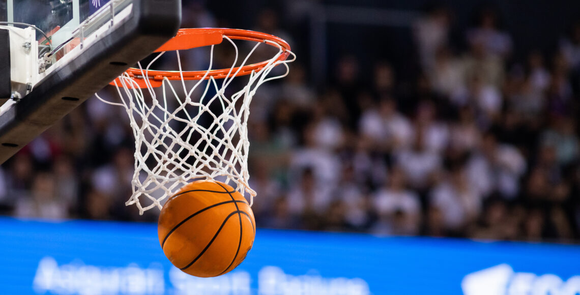 A basketball swishes through a hoop.